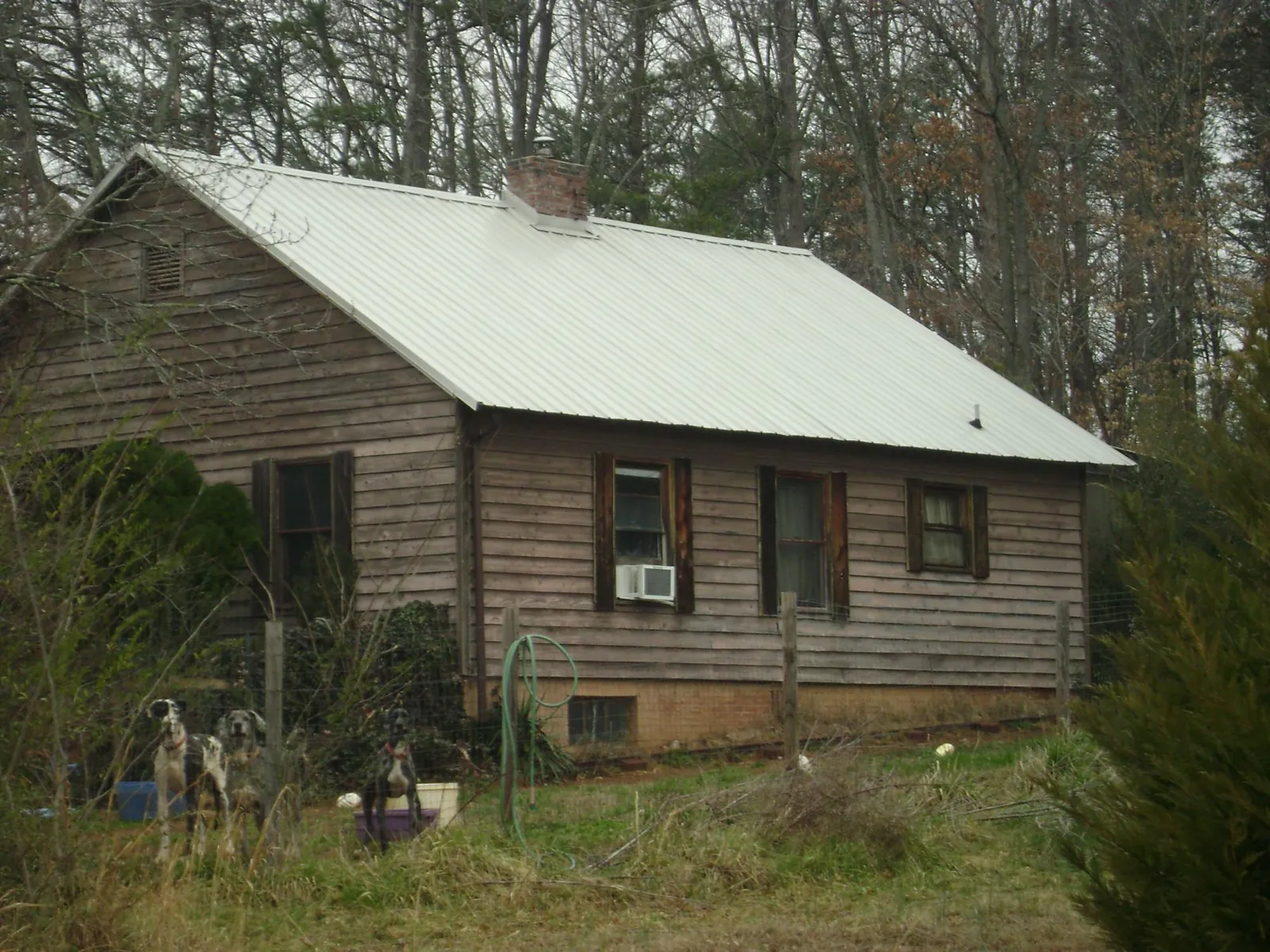 White metal roof on an old wood sided farmhouse, from a Metal Roof Installation job in Ashland